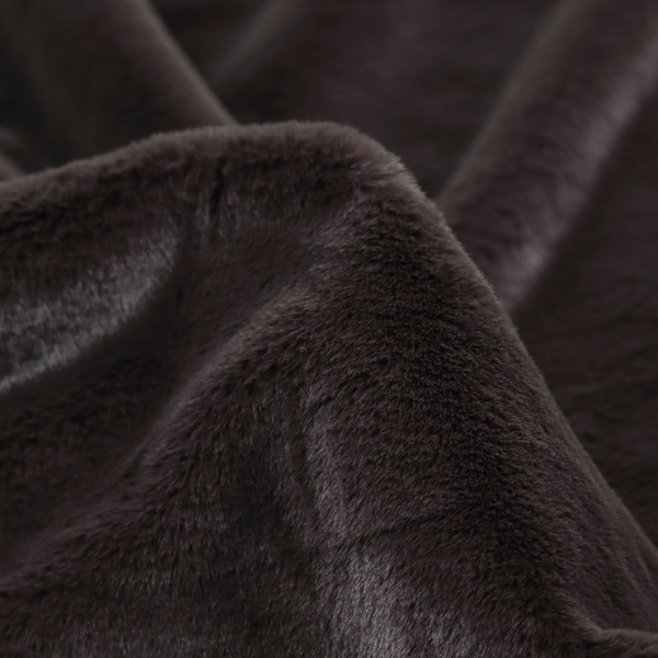 A luxurious faux fur fabric in a deep off-black or charcoal noir shade. The material has an exceptionally dense, short-pile texture that creates a rich, velvet-like surface. The dark fibres catch the light to reveal subtle, cool-toned depth, giving the fabric a sophisticated matte finish.