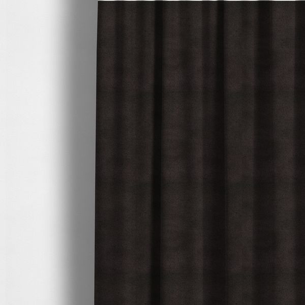 The fabric used to create these made-to-measure curtains is a luxurious faux fur fabric in a deep off-black or charcoal noir shade. The material has an exceptionally dense, short-pile texture that creates a rich, velvet-like surface. The dark fibres catch the light to reveal subtle, cool-toned depth, giving the fabric a sophisticated matte finish.