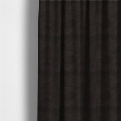The fabric used to create these made-to-measure curtains is a luxurious faux fur fabric in a deep off-black or charcoal noir shade. The material has an exceptionally dense, short-pile texture that creates a rich, velvet-like surface. The dark fibres catch the light to reveal subtle, cool-toned depth, giving the fabric a sophisticated matte finish.