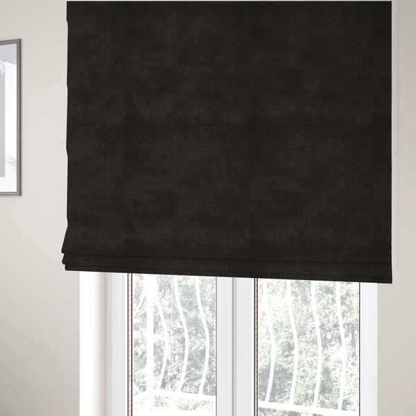 The fabric used to create these Roman blinds is a luxurious faux fur fabric in a deep off-black or charcoal noir shade. The material has an exceptionally dense, short-pile texture that creates a rich, velvet-like surface. The dark fibres catch the light to reveal subtle, cool-toned depth, giving the fabric a sophisticated matte finish.
