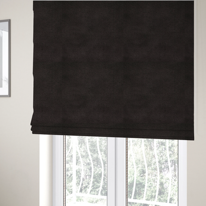 The fabric used to create these Roman blinds is a luxurious faux fur fabric in a deep off-black or charcoal noir shade. The material has an exceptionally dense, short-pile texture that creates a rich, velvet-like surface. The dark fibres catch the light to reveal subtle, cool-toned depth, giving the fabric a sophisticated matte finish.