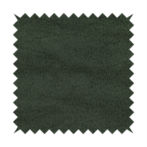 A plush faux fur fabric in a rich forest green or deep pine colour. The material has a dense, short-pile texture that creates a velvety surface with a sophisticated matte finish. The dark green fibres are tightly packed, showing subtle tonal variations and soft shadows that give the fabric a luxurious sense of depth.