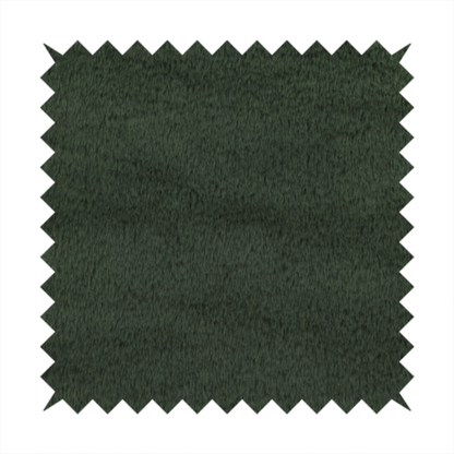 A plush faux fur fabric in a rich forest green or deep pine colour. The material has a dense, short-pile texture that creates a velvety surface with a sophisticated matte finish. The dark green fibres are tightly packed, showing subtle tonal variations and soft shadows that give the fabric a luxurious sense of depth.