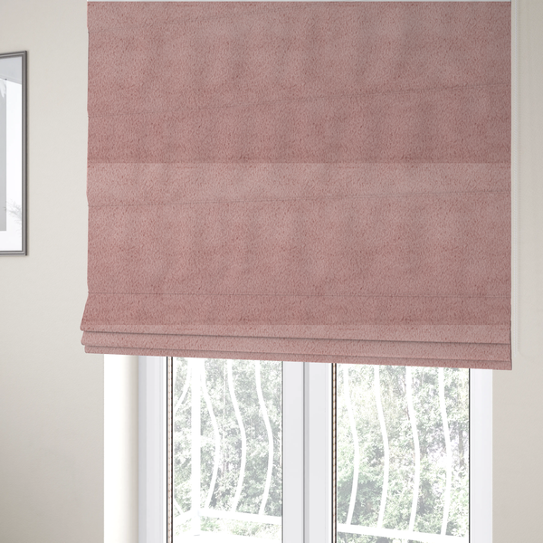 The fabric used to create these Roman blinds is a plush faux fur fabric in a delicate dusty rose or muted blush pink. The material displays a dense, short-pile texture that creates a velvety surface with a soft, matte finish. The tightly packed fibres catch the light to show gentle tonal shifts, giving the fabric a romantic and luxurious sense of depth.