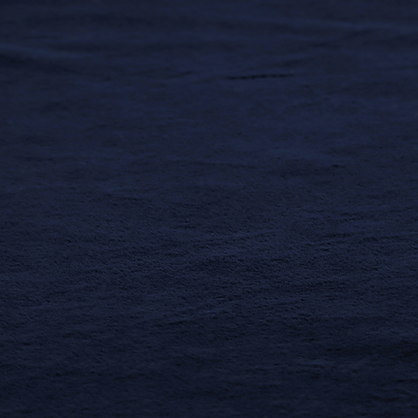 A plush faux fur fabric in a deep, classic navy blue. The material features a dense, short-pile texture that creates a rich, velvety surface with a sophisticated matte finish. The tightly packed dark blue fibres catch the light to show subtle tonal depth and soft shadows, suggesting an exceptionally soft and luxurious hand-feel.