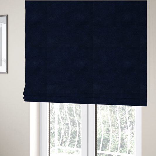 The fabric used to create these Roman blinds is a plush faux fur fabric in a deep, classic navy blue. The material features a dense, short-pile texture that creates a rich, velvety surface with a sophisticated matte finish. The tightly packed dark blue fibres catch the light to show subtle tonal depth and soft shadows, suggesting an exceptionally soft and luxurious hand-feel.
