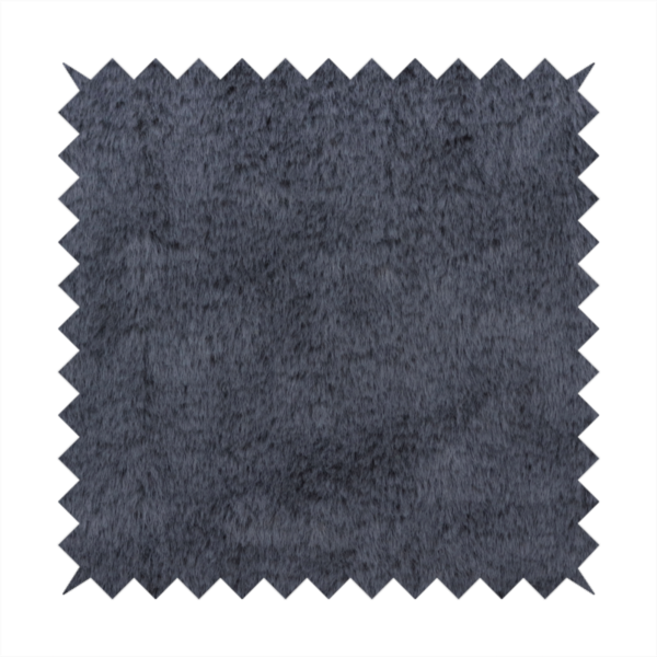 A luxurious faux fur fabric in a deep slate grey or charcoal blue shade. The material features a dense, plush, short-pile texture that creates a soft, uniform surface with a rich matte finish. The tightly packed fibres catch the light to reveal subtle, cool-toned depth and soft shadows, suggesting a velvety and sophisticated hand-feel.