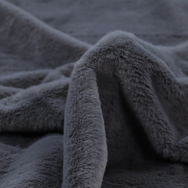A luxurious faux fur fabric in a deep slate grey or charcoal blue shade. The material features a dense, plush, short-pile texture that creates a soft, uniform surface with a rich matte finish. The tightly packed fibres catch the light to reveal subtle, cool-toned depth and soft shadows, suggesting a velvety and sophisticated hand-feel.
