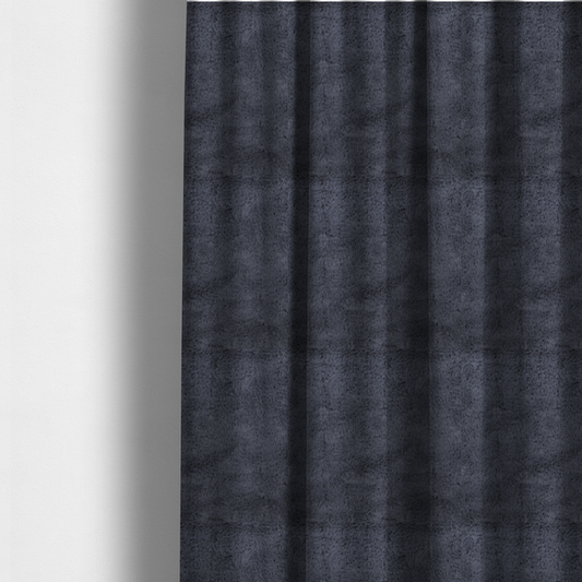 The fabric used to create these made-to-measure curtains is a luxurious faux fur fabric in a deep slate grey or charcoal blue shade. The material features a dense, plush, short-pile texture that creates a soft, uniform surface with a rich matte finish. The tightly packed fibres catch the light to reveal subtle, cool-toned depth and soft shadows, suggesting a velvety and sophisticated hand-feel.