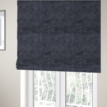 The fabric used to create these Roman blinds is a luxurious faux fur fabric in a deep slate grey or charcoal blue shade. The material features a dense, plush, short-pile texture that creates a soft, uniform surface with a rich matte finish. The tightly packed fibres catch the light to reveal subtle, cool-toned depth and soft shadows, suggesting a velvety and sophisticated hand-feel.