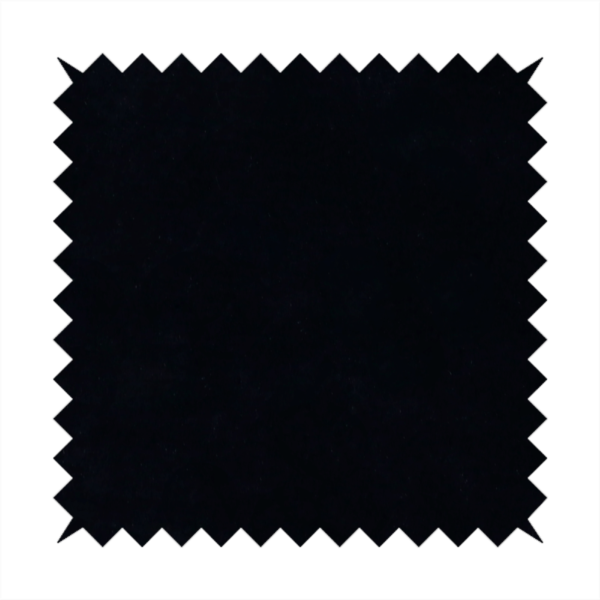 A luxurious faux fur fabric in a solid, true jet black. The material showcases an exceptionally dense, short-pile texture with a soft, uniform grain that creates a deep matte finish. Because of its high density, the fabric absorbs light significantly, resulting in a rich, velvety appearance with minimal sheen.