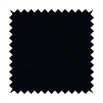 A luxurious faux fur fabric in a solid, true jet black. The material showcases an exceptionally dense, short-pile texture with a soft, uniform grain that creates a deep matte finish. Because of its high density, the fabric absorbs light significantly, resulting in a rich, velvety appearance with minimal sheen.