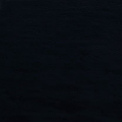 A luxurious faux fur fabric in a solid, true jet black. The material showcases an exceptionally dense, short-pile texture with a soft, uniform grain that creates a deep matte finish. Because of its high density, the fabric absorbs light significantly, resulting in a rich, velvety appearance with minimal sheen.