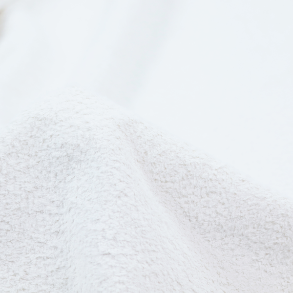 This fabric features a high-pile, textured surface that mimics the cosy appearance of shearling or faux sheepskin.