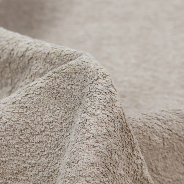 This fabric features a high-pile faux fur texture that offers a warm, neutral aesthetic with a soft and tactile quality.