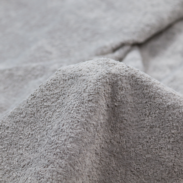 This fabric features a high-pile faux fur texture that offers a sophisticated, cool-neutral aesthetic with a soft and tactile quality.