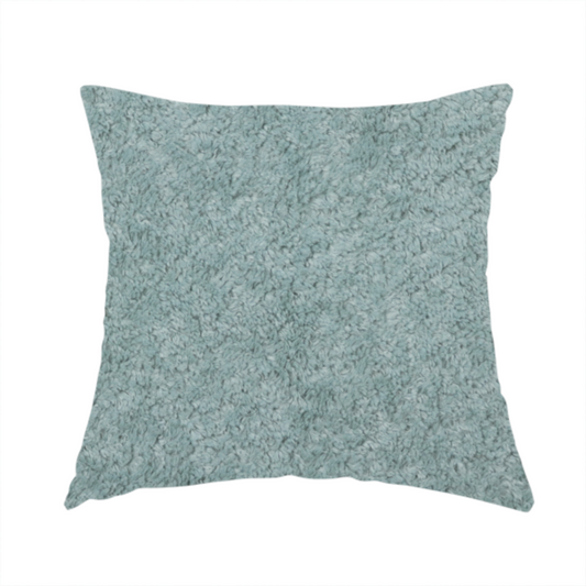 The fabric used to create this handmade cushion is a soft, textured fabric in a muted, calming shade of blue. The surface features a dense, uniform, and plush pile texture.