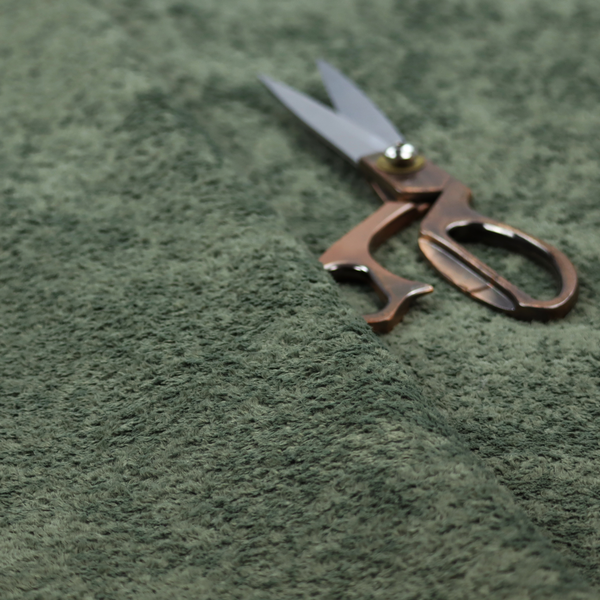 A soft, textured fabric in a rich, earthy green shade. The surface features a dense, uniform, and plush pile, characteristic of thick fleece or absorbent terry cloth material.