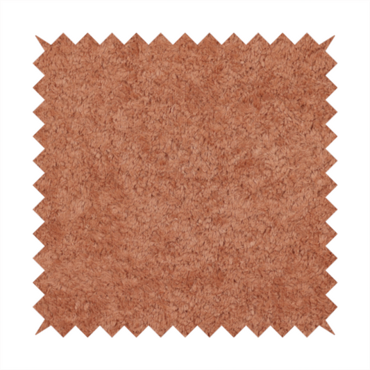 A soft, textured fabric in a warm, muted terracotta or rust shade. The surface features a dense, uniform, and plush pile, characteristic of thick fleece or absorbent terry cloth material.