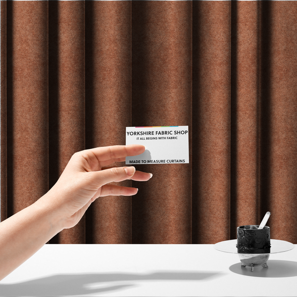 The fabric used to create these made-to-measure curtains is a soft, textured fabric in a warm, muted terracotta or rust shade. The surface features a dense, uniform, and plush pile, characteristic of thick fleece or absorbent terry cloth material.