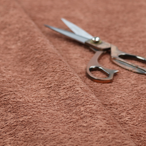 A soft, textured fabric in a muted, dusty rose shade, featuring a dense, uniform, and plush pile like thick fleece or terry.