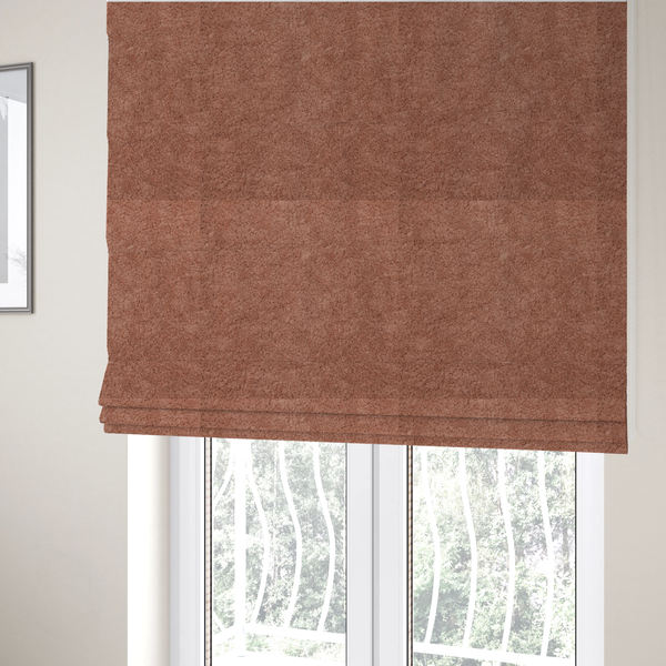 The fabric used to create these Roman blinds is a soft, textured fabric in a muted, dusty rose shade, featuring a dense, uniform, and plush pile like thick fleece or terry.