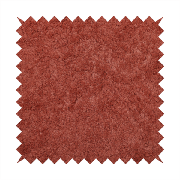 A soft, textured fabric in a deep, warm reddish-terracotta shade. The surface features a dense, uniform, and plush pile, characteristic of thick fleece or absorbent material.