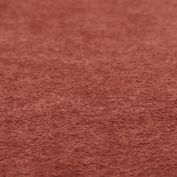 A soft, textured fabric in a deep, warm reddish-terracotta shade. The surface features a dense, uniform, and plush pile, characteristic of thick fleece or absorbent material.