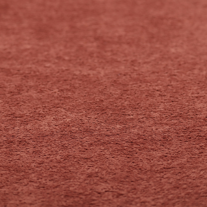 A soft, textured fabric in a deep, warm reddish-terracotta shade. The surface features a dense, uniform, and plush pile, characteristic of thick fleece or absorbent material.