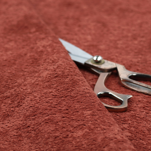 A soft, textured fabric in a deep, warm reddish-terracotta shade. The surface features a dense, uniform, and plush pile, characteristic of thick fleece or absorbent material.