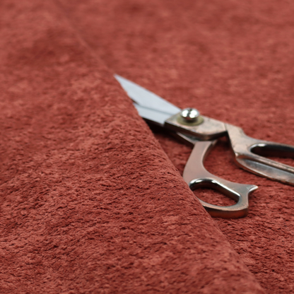 A soft, textured fabric in a deep, warm reddish-terracotta shade. The surface features a dense, uniform, and plush pile, characteristic of thick fleece or absorbent material.