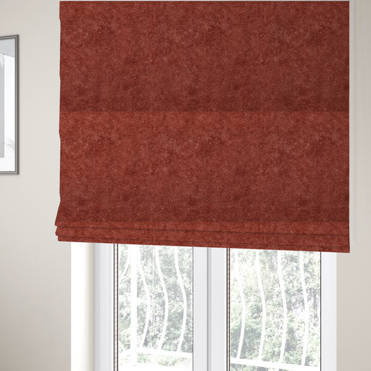 The fabric used to create these Roman blinds is a soft, textured fabric in a deep, warm reddish-terracotta shade. The surface features a dense, uniform, and plush pile, characteristic of thick fleece or absorbent material.