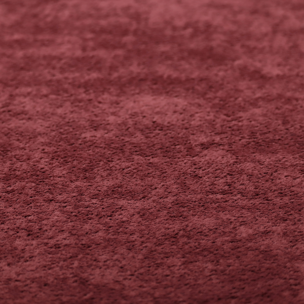 A plush, deep burgundy fabric featuring a dense, uniform, and textured pile.