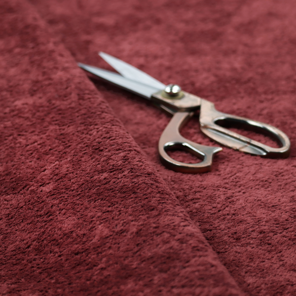 A plush, deep burgundy fabric featuring a dense, uniform, and textured pile.