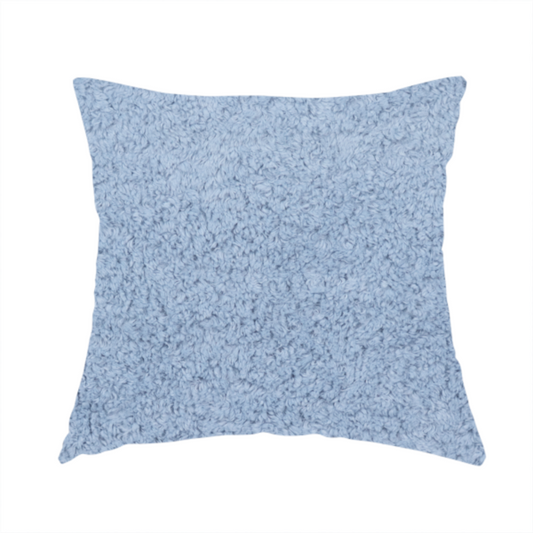 The fabric used to create this handmade cushion is a soft, light blue fabric with a dense, uniform, and plush pile.