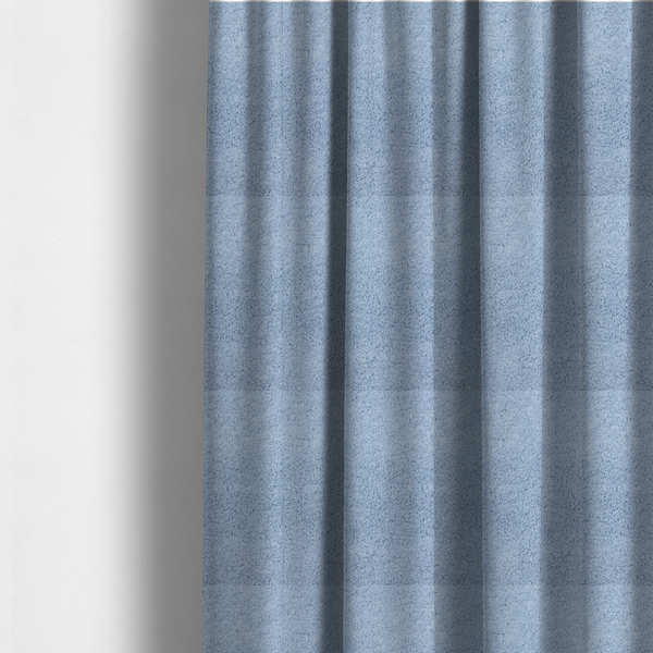 The fabric used to create these made-to-measure curtains is a soft, light blue fabric with a dense, uniform, and plush pile.