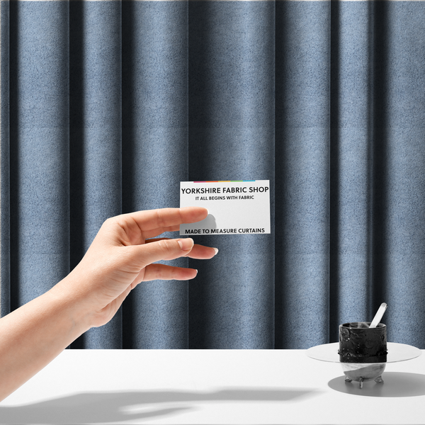 The fabric used to create these made-to-measure curtains is a soft, light blue fabric with a dense, uniform, and plush pile.