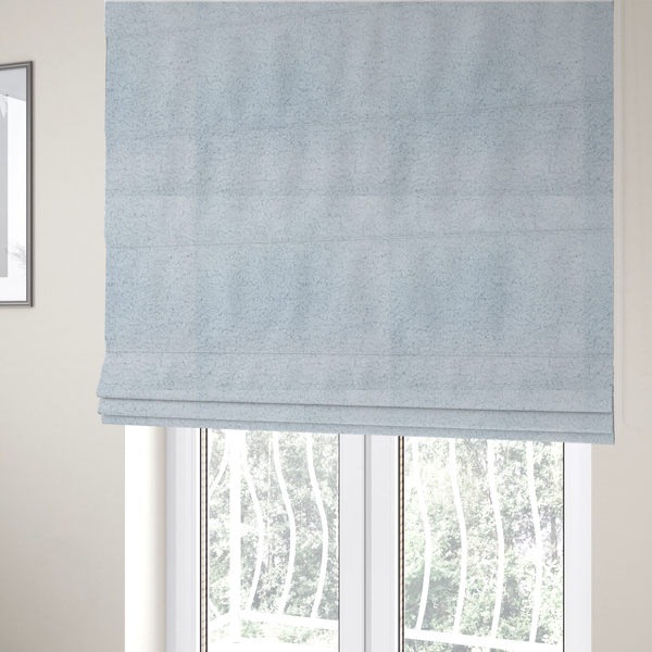 The fabric used to create these Roman blinds is a soft, pale blue fabric with a dense, uniform, and plush pile.
