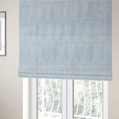 The fabric used to create these Roman blinds is a soft, pale blue fabric with a dense, uniform, and plush pile.