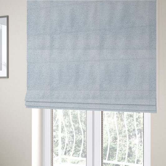 The fabric used to create these Roman blinds is a soft, pale blue fabric with a dense, uniform, and plush pile.