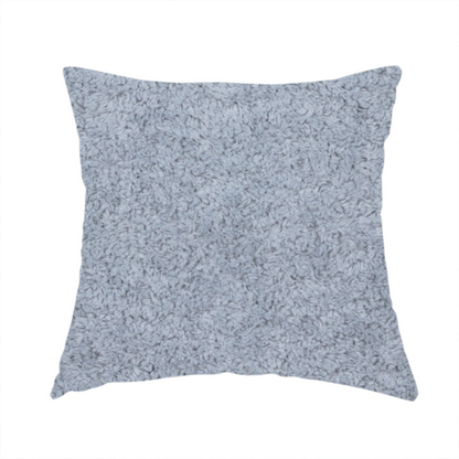 The fabric used to create this handmade cushion is a soft greyish-blue fabric with a dense, uniform, textured pile like thick fleece.