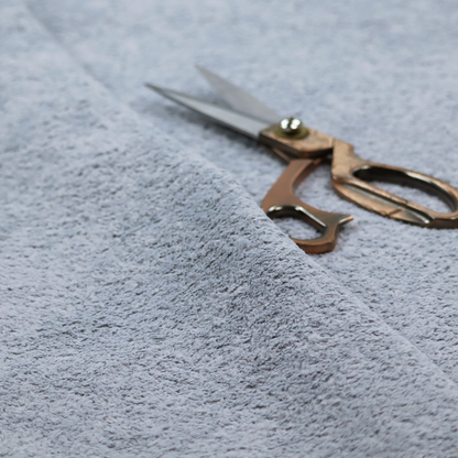 A soft greyish-blue fabric with a dense, uniform, textured pile like thick fleece.