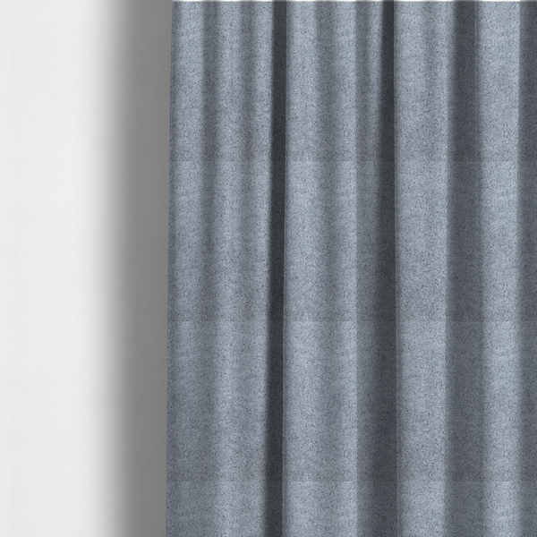 The fabric used to create these made-to-measure curtains is a soft greyish-blue fabric with a dense, uniform, textured pile like thick fleece.