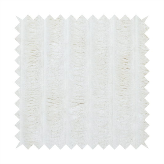 A cream-coloured textile featuring a repeating, vertical ribbed pattern. The fabric alternates between wide, soft, faux-fur-like plush bands and narrow, smooth, flat channels.