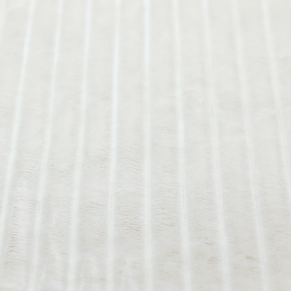 A cream-coloured textile featuring a repeating, vertical ribbed pattern. The fabric alternates between wide, soft, faux-fur-like plush bands and narrow, smooth, flat channels.