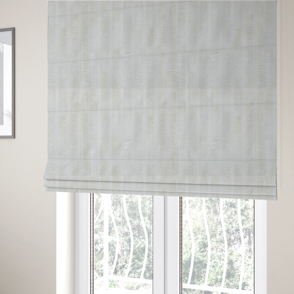 The fabric used to create these Roman blinds is a cream-coloured textile featuring a repeating, vertical ribbed pattern. The fabric alternates between wide, soft, faux-fur-like plush bands and narrow, smooth, flat channels.
