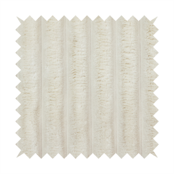 A detailed view of a light beige or cream-coloured textile featuring a repeating, vertical channel-tufted pattern. The material alternates between soft, high-pile plush bands and thin, compressed vertical lines.