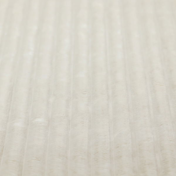 A detailed view of a light beige or cream-coloured textile featuring a repeating, vertical channel-tufted pattern. The material alternates between soft, high-pile plush bands and thin, compressed vertical lines.