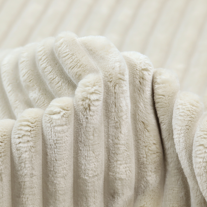A detailed view of a light beige or cream-coloured textile featuring a repeating, vertical channel-tufted pattern. The material alternates between soft, high-pile plush bands and thin, compressed vertical lines.