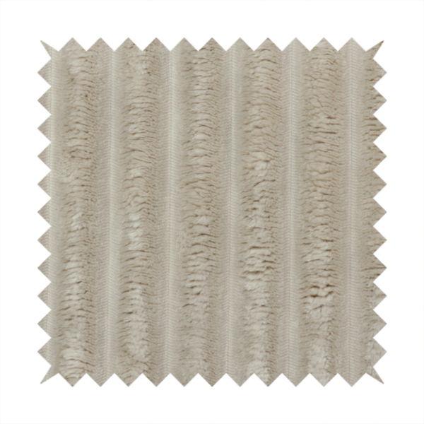 A warm, beige-toned textile featuring a repeating, vertical channel-tufted pattern. The fabric alternates between thick, high-pile plush bands and thin, compressed vertical channels.